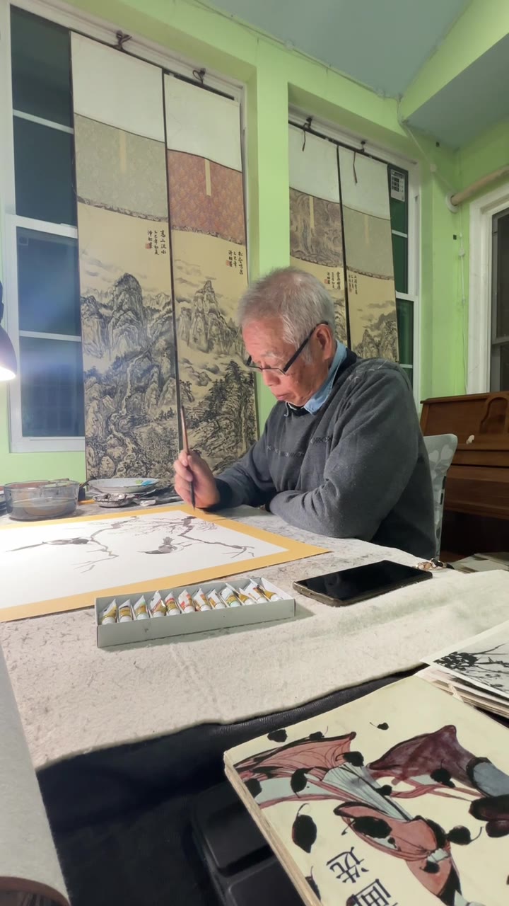 聂泽昭 painting at his table