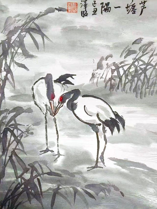 Two red-crowned cranes standing among reeds