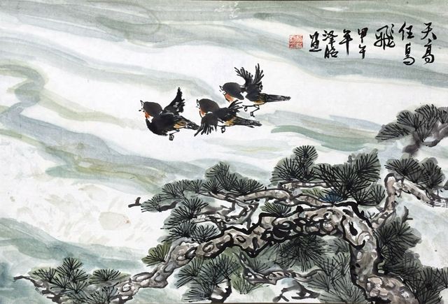Three birds flying over pines
